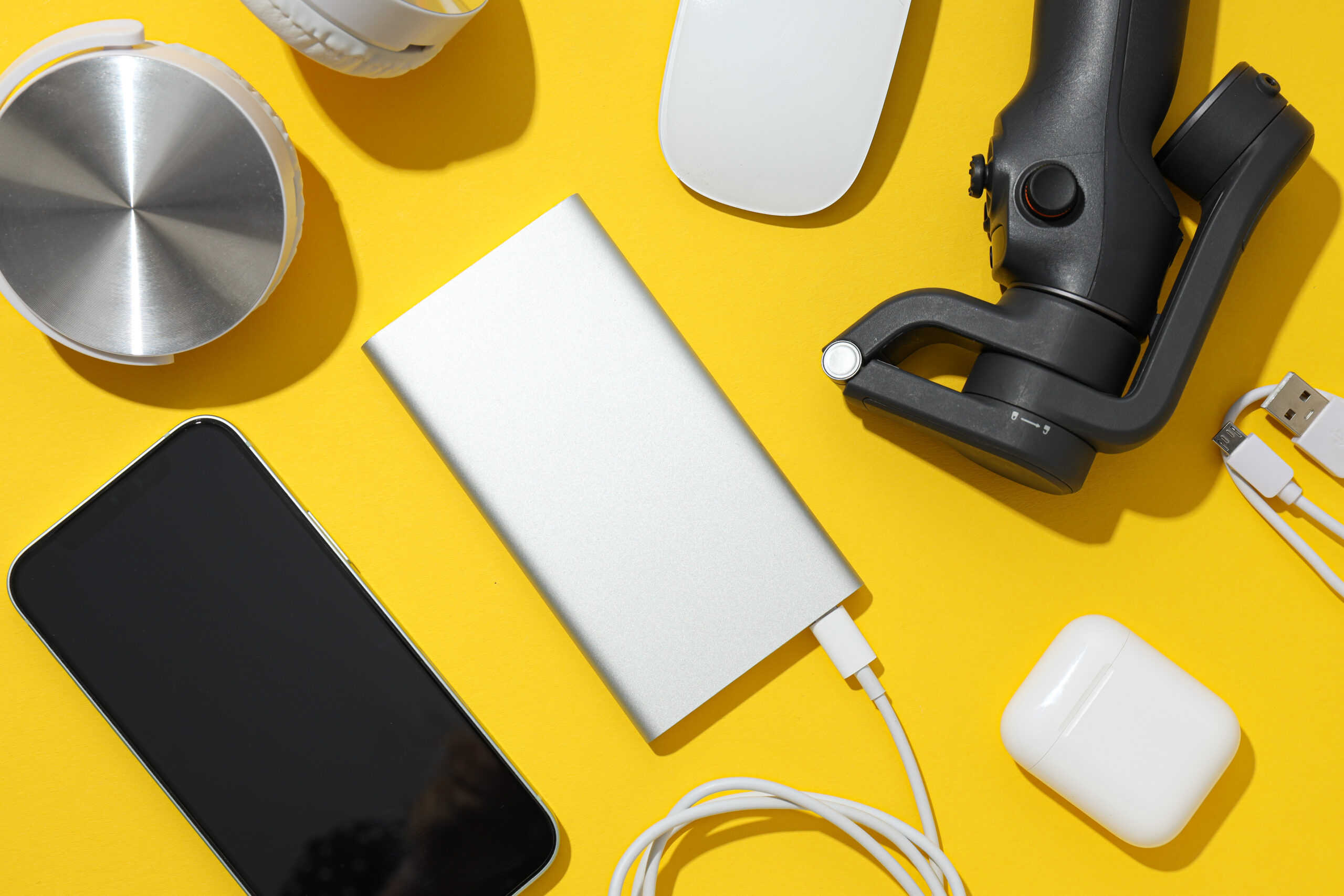 Power banks and headphones on yellow background, top view Power banks and headphones on yellow background, top view
